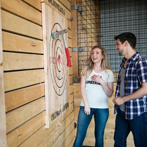 People celebrating a thrown axe that hit the bullseye